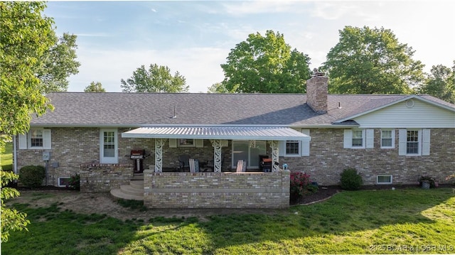 907 Sunnyview Cir, Eldon, MO 65026 - rear view of property featuring a lawn, brick siding, a chimney, roof with shingles, and a patio