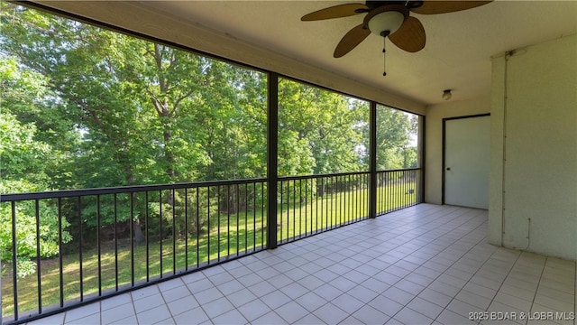 unfurnished sunroom featuring a ceiling fan