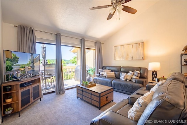 living area with carpet flooring, vaulted ceiling, and a ceiling fan