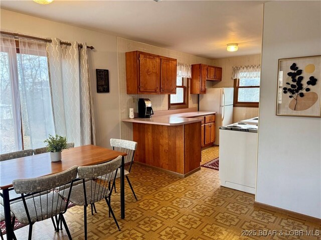 30020 Cool Valley Dr, Rocky Mount, MO 65072 - kitchen with brown cabinetry, range, light countertops, and light flooring