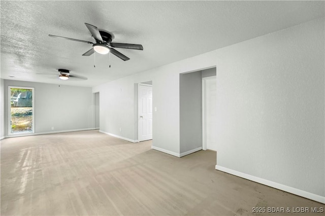 empty room with ceiling fan, baseboards, and a textured ceiling