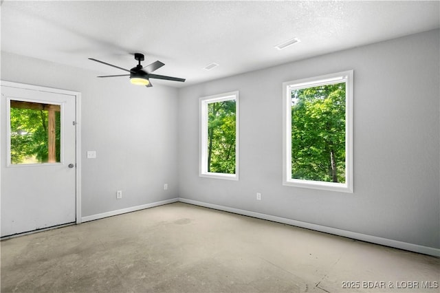 spare room with concrete flooring, baseboards, and a ceiling fan