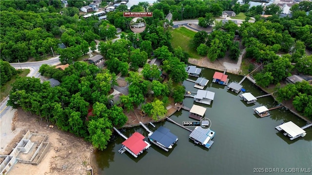 drone / aerial view of a nearby body of water and a tree filled landscape