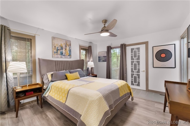 bedroom featuring light wood-style flooring, a ceiling fan, access to outside, and baseboards