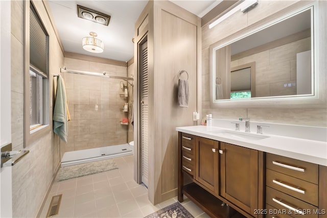 full bath featuring tile patterned flooring, a shower stall, and vanity