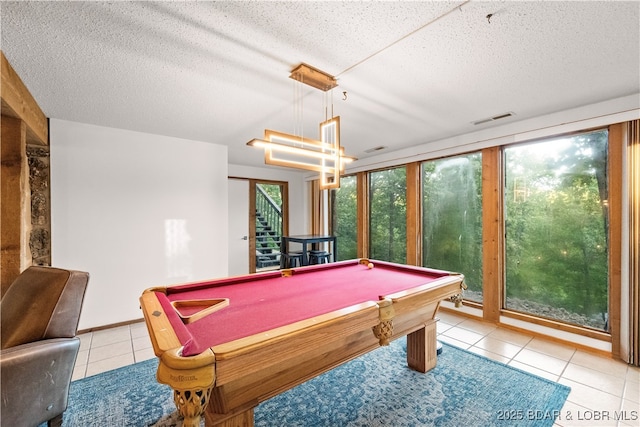 recreation room with light tile patterned floors, billiards table, a textured ceiling, and a chandelier
