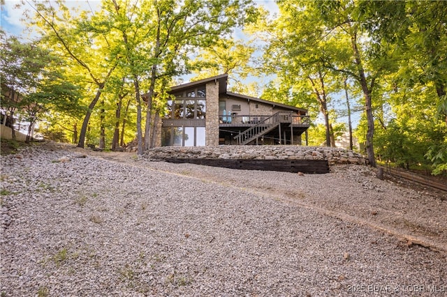 back of property featuring stairs and a wooden deck