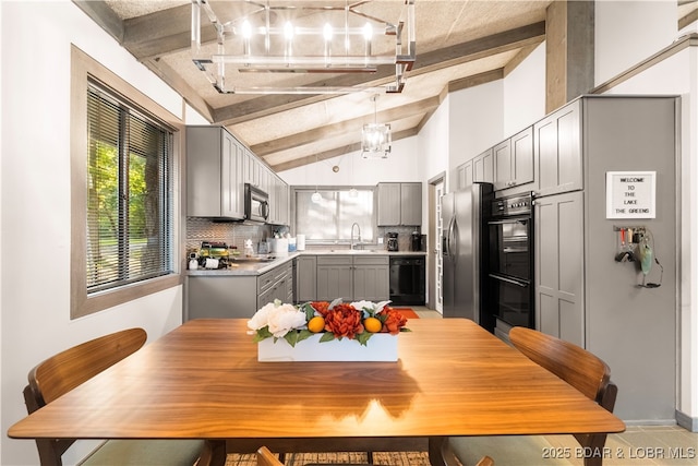 kitchen featuring gray cabinetry, black appliances, a sink, light countertops, and decorative backsplash