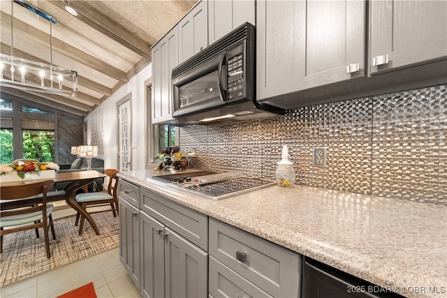 kitchen featuring black microwave, stainless steel gas cooktop, decorative backsplash, gray cabinetry, and light tile patterned floors