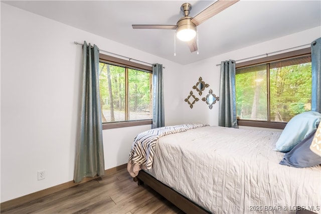 bedroom featuring wood finished floors, baseboards, and a ceiling fan