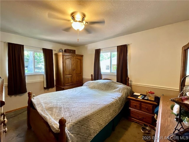 carpeted bedroom with a textured ceiling, ceiling fan, and baseboards