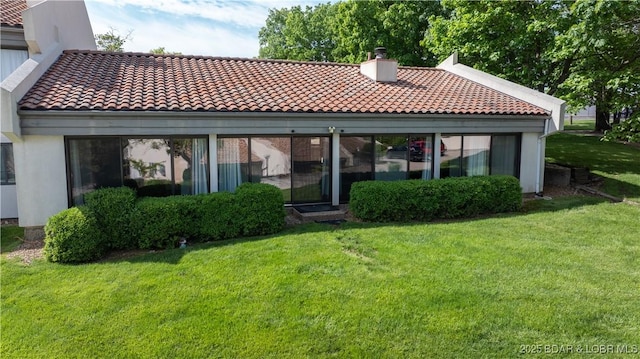 19 Casa Blanca Ct Unit 219, Lake Ozark, MO 65049 - rear view of property featuring a chimney, a tile roof, a yard, and stucco siding