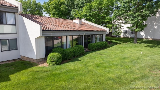 19 Casa Blanca Ct Unit 219, Lake Ozark, MO 65049 - back of property with a tiled roof, a lawn, a chimney, and stucco siding