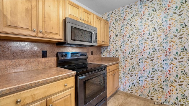 19 Casa Blanca Ct Unit 219, Lake Ozark, MO 65049 - kitchen with wallpapered walls, black electric range, stainless steel microwave, baseboards, and tasteful backsplash