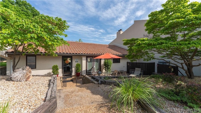 19 Casa Blanca Ct Unit 219, Lake Ozark, MO 65049 - view of front of home featuring stucco siding, a tile roof, fence, and a chimney