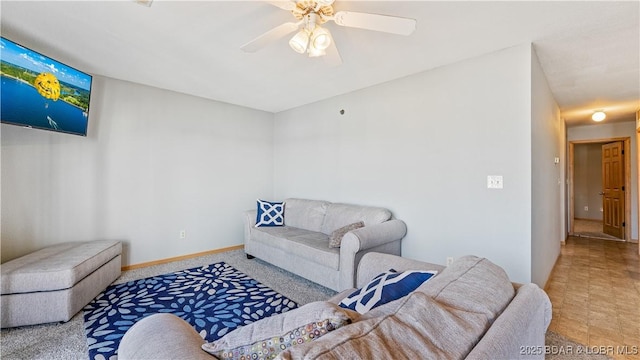 living room featuring a ceiling fan and baseboards