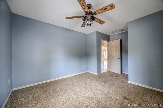carpeted empty room with ceiling fan and baseboards