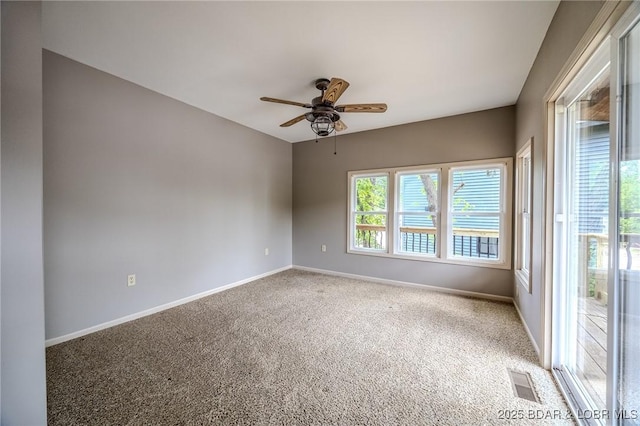 spare room with a ceiling fan, light colored carpet, and baseboards