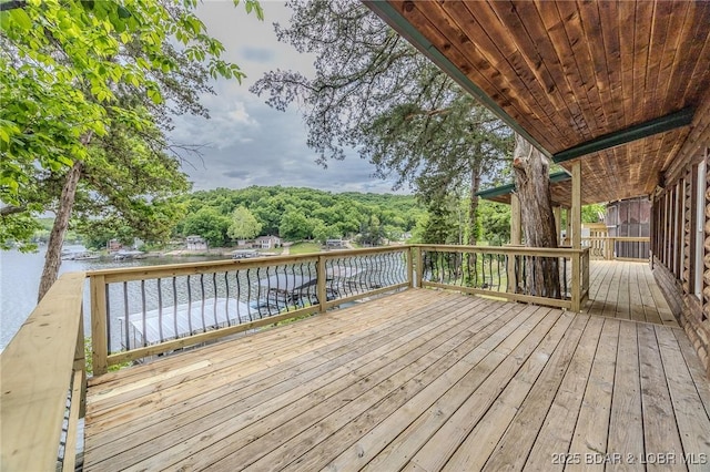 wooden terrace featuring a water view and a wooded view