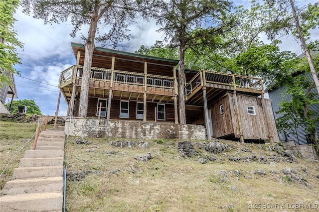 back of house featuring stairs and a wooden deck