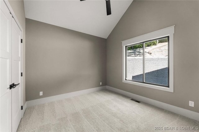unfurnished room with a ceiling fan, light carpet, lofted ceiling, and baseboards