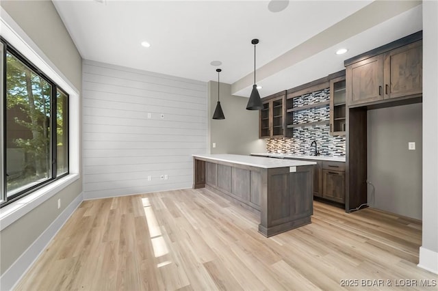 bar with tasteful backsplash, light wood-style flooring, pendant lighting, recessed lighting, and baseboards