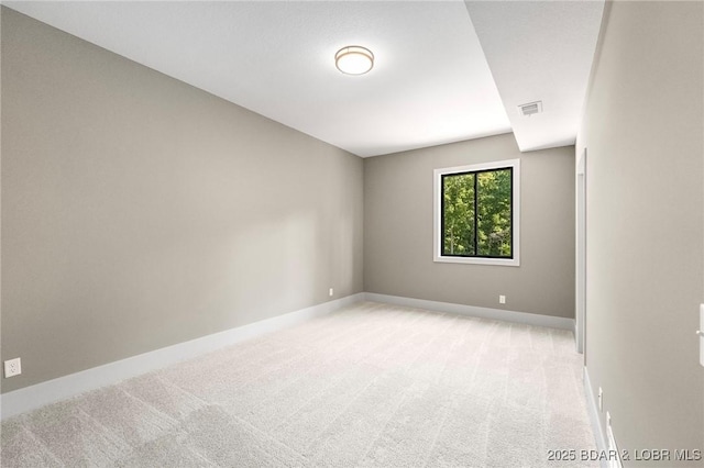 unfurnished room featuring light colored carpet and baseboards