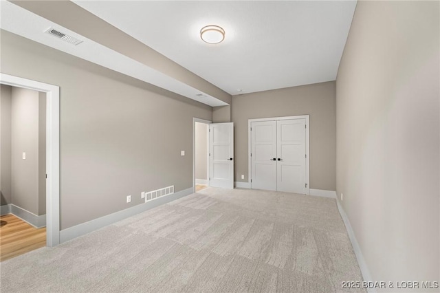 unfurnished bedroom with carpet, baseboards, and a closet