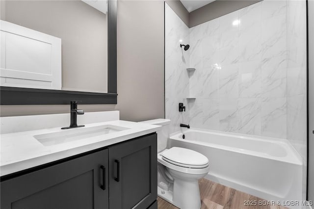 bathroom with wood finished floors, toilet, vanity, and shower / bathtub combination