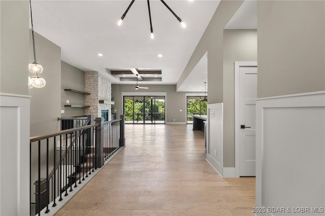 corridor with light wood finished floors, a chandelier, recessed lighting, and baseboards