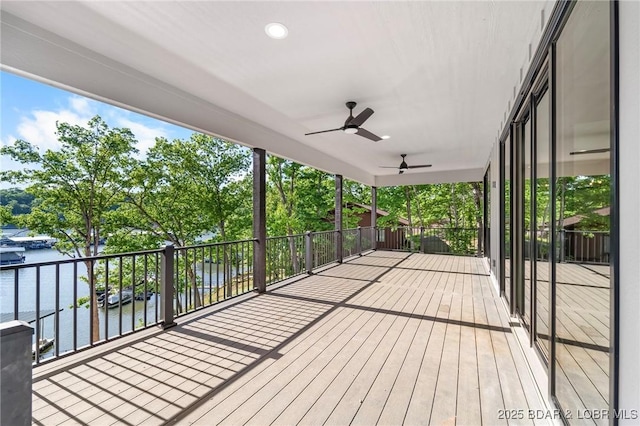 wooden terrace featuring a water view and a ceiling fan