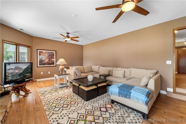 living area featuring ceiling fan, light wood-style floors, and baseboards