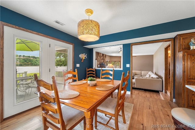 dining space with light wood-style flooring, baseboards, and a ceiling fan