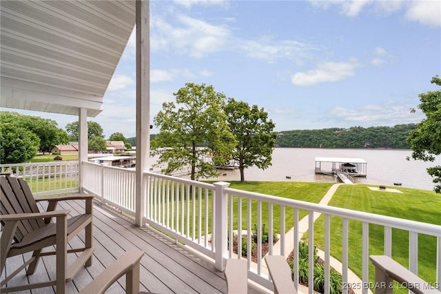 wooden deck featuring a water view and a lawn