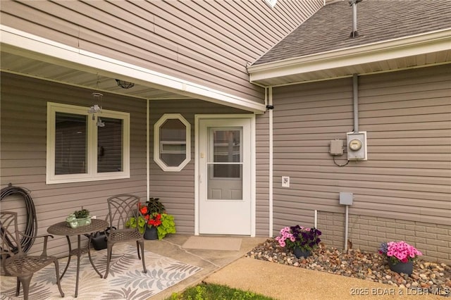 property entrance featuring a shingled roof
