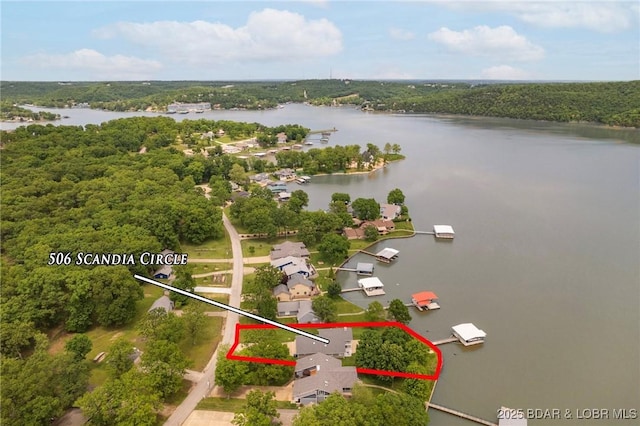 aerial view of property's location with a large body of water, property parcel outlined, and a forest