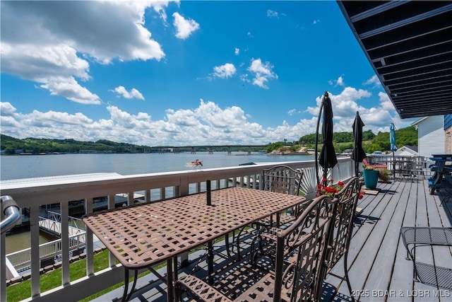 wooden deck featuring a water view and outdoor dining area