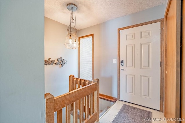 tiled foyer entrance with a textured ceiling