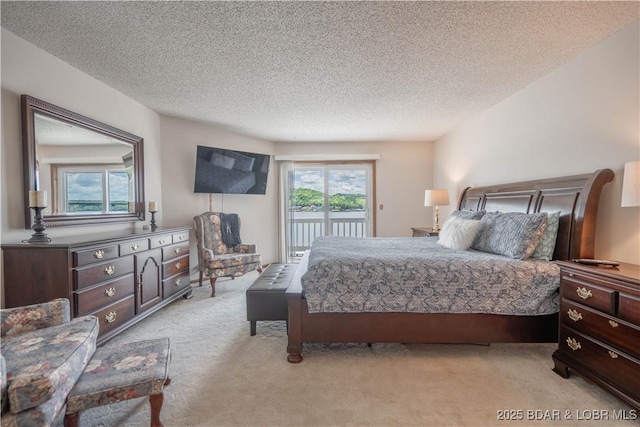bedroom with access to outside, light carpet, and a textured ceiling