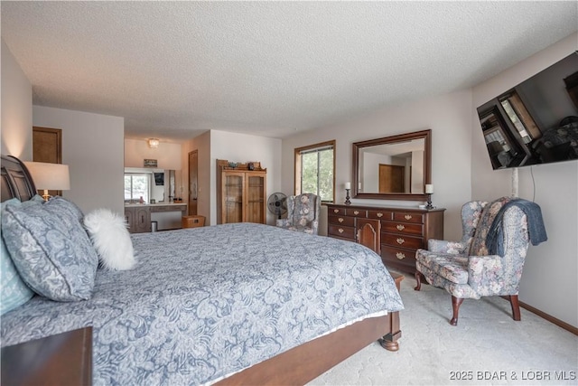 bedroom featuring light colored carpet, a textured ceiling, and baseboards