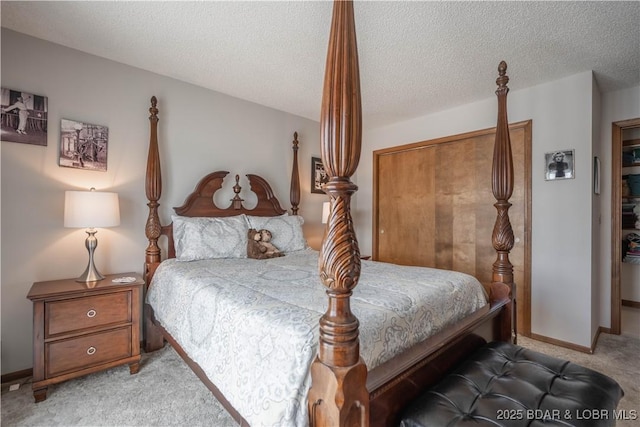 bedroom featuring light carpet, a textured ceiling, and baseboards