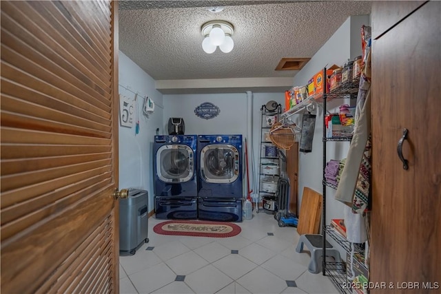 clothes washing area with independent washer and dryer and a textured ceiling
