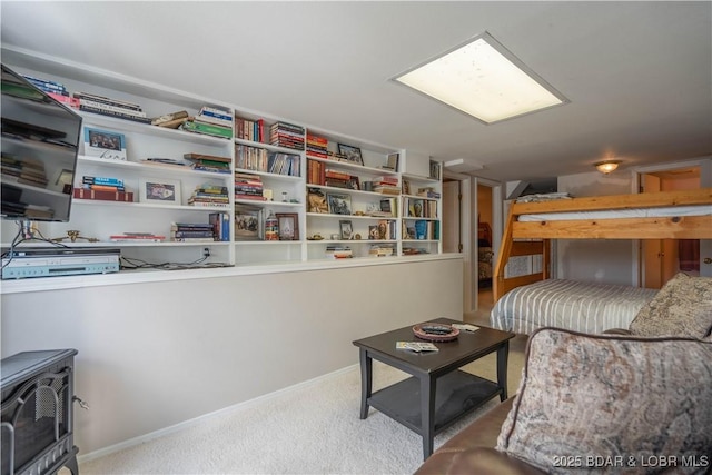 carpeted bedroom featuring a wood stove and baseboards