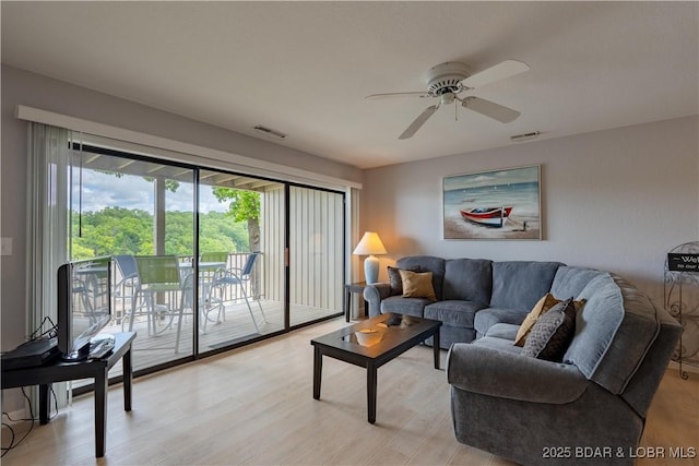 living room featuring a ceiling fan and light wood-type flooring