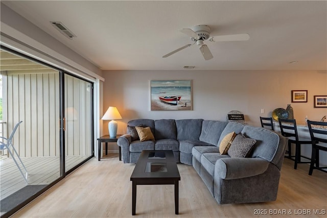 living area featuring light wood-style floors and a ceiling fan