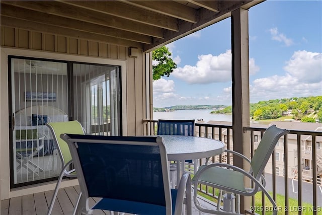 wooden deck featuring a water view and outdoor dining area