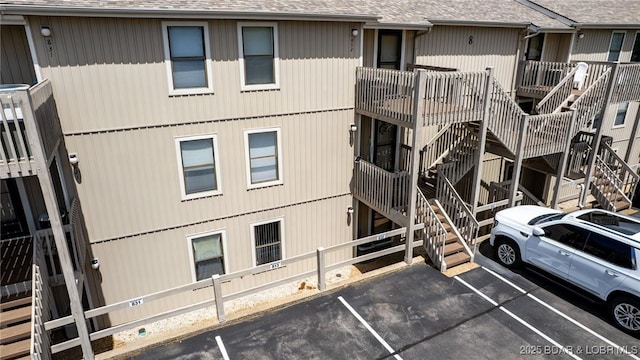 view of building exterior featuring uncovered parking and stairs