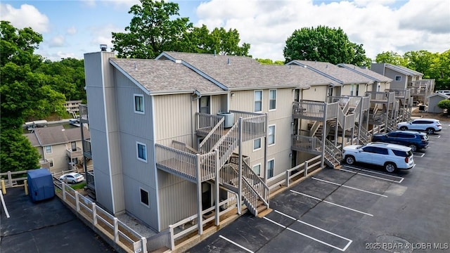 view of building exterior with uncovered parking and stairs
