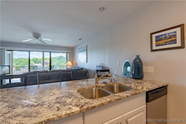 kitchen with dishwasher, a sink, light stone countertops, and white cabinetry
