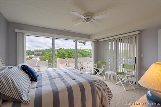 carpeted bedroom with access to exterior, multiple windows, and a ceiling fan